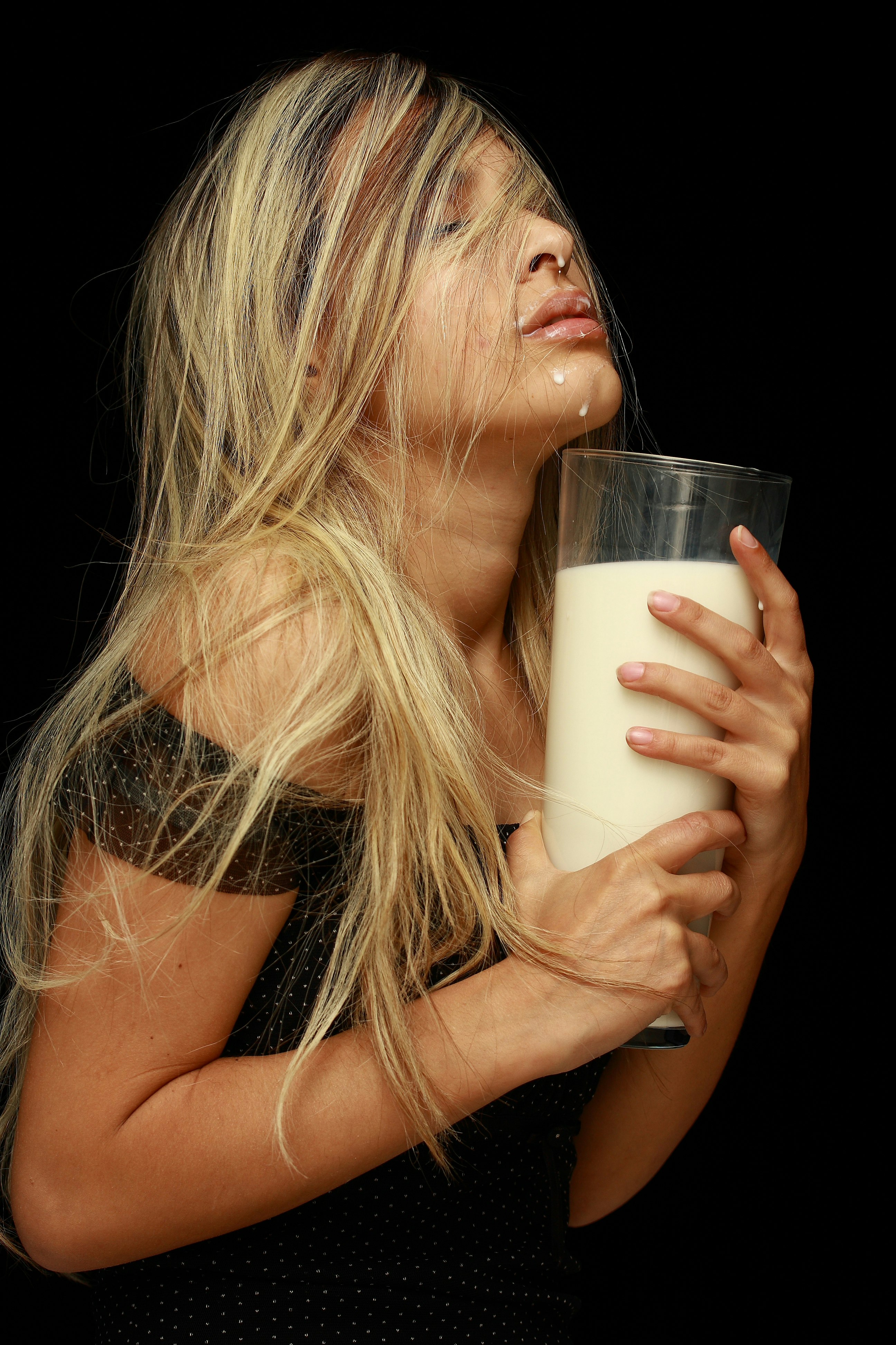 woman holding clear drinking glass with white liquid